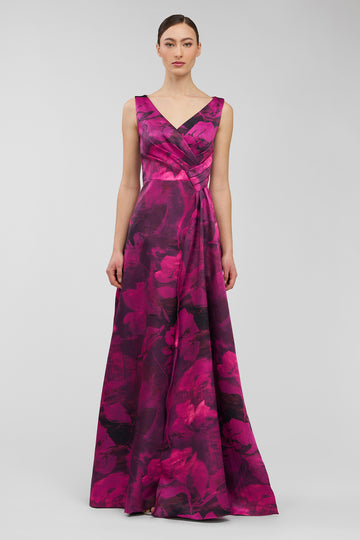 Woman wearing a vibrant pink and purple floral patterned dress on a light gray background