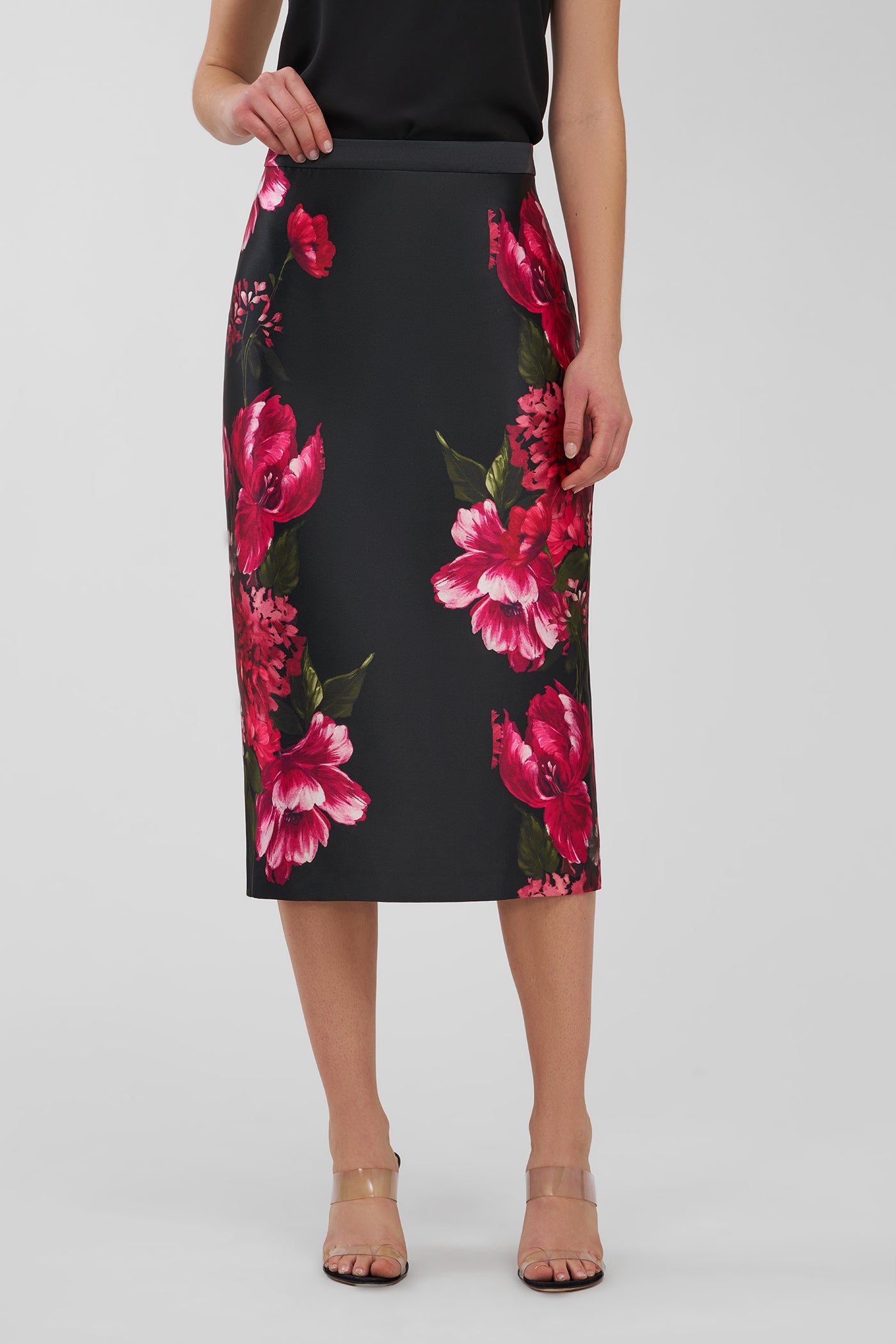 Black pencil skirt with pink floral pattern worn by a person on a white background
