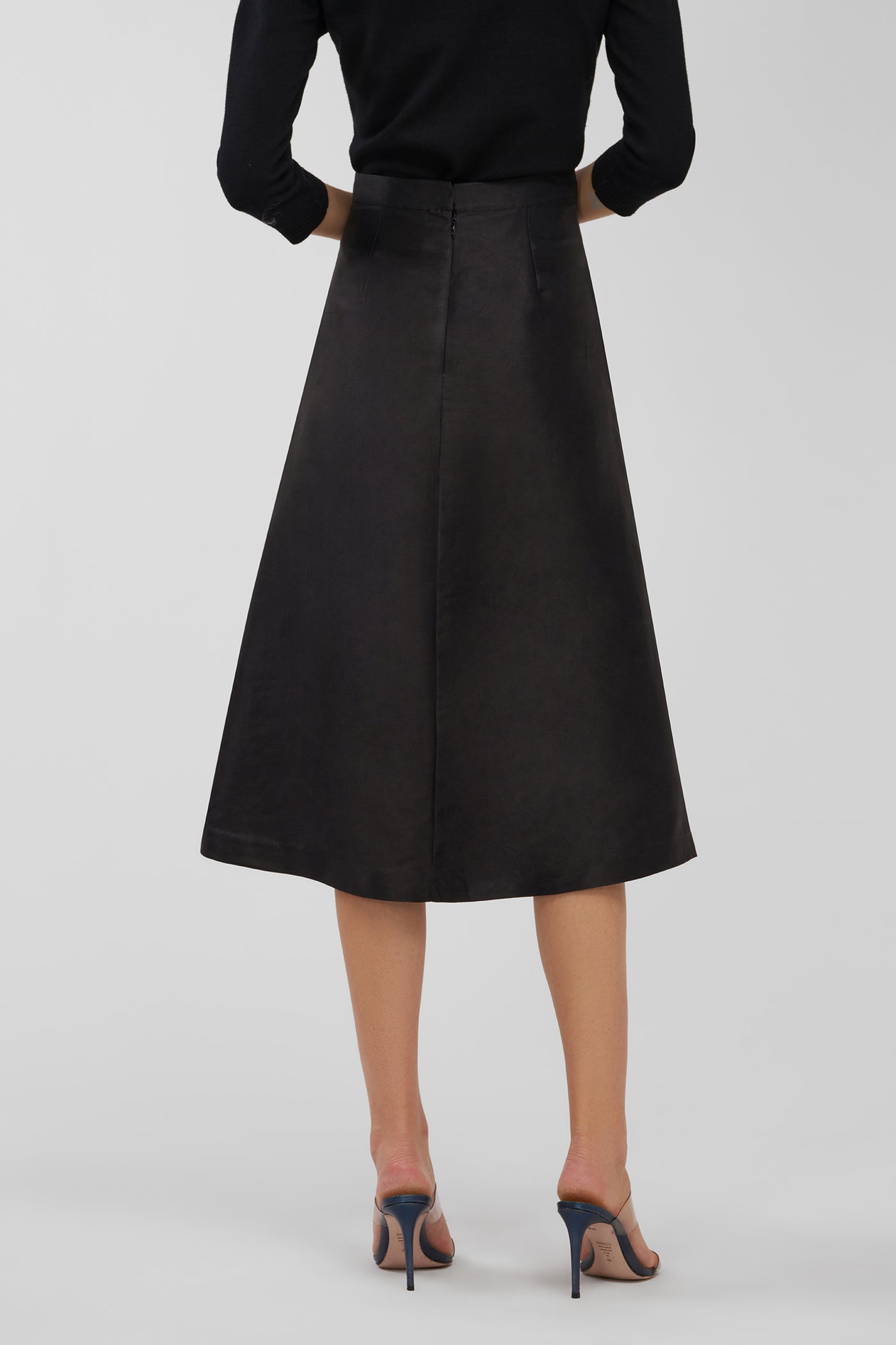 Black skirt worn by a person on a white background