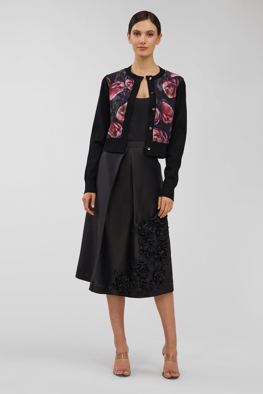 Woman wearing a black outfit with floral jacket on a white background