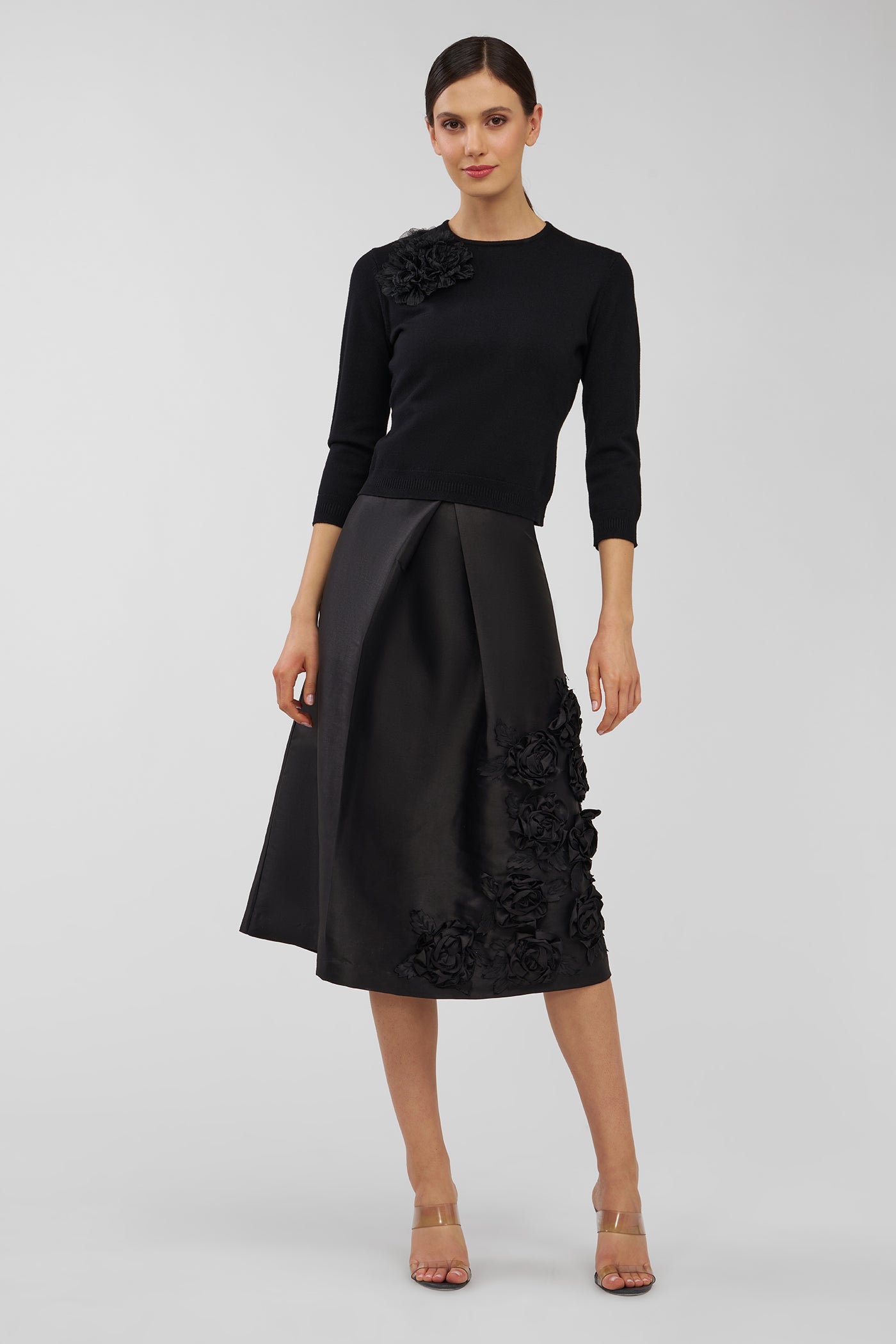 Woman wearing a black skirt with floral details on a white background