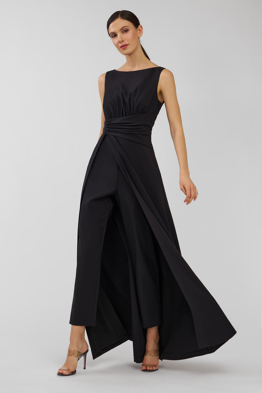 Woman wearing a black sleeveless walk thru jumpsuit on a white background