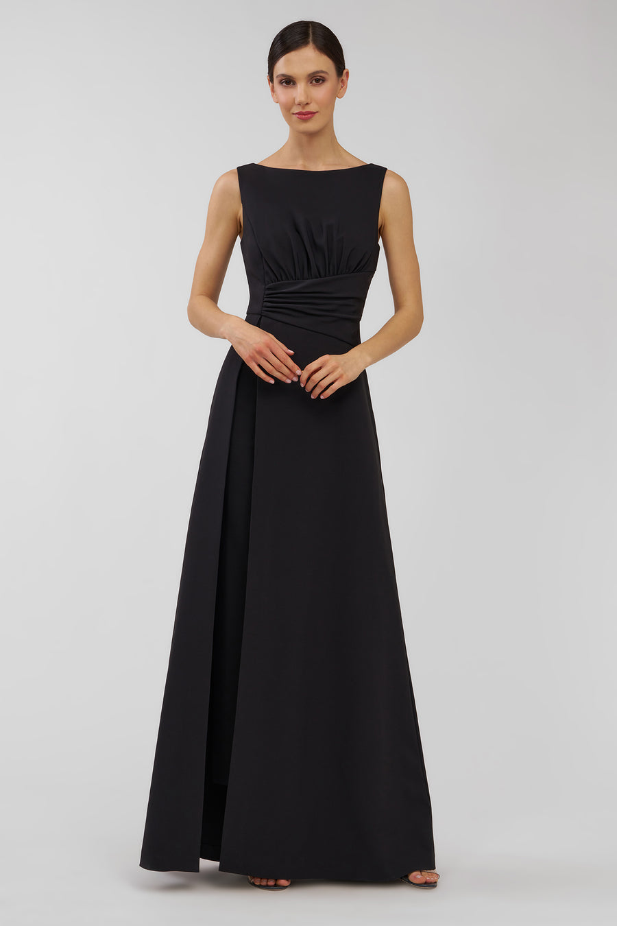 Woman wearing a black sleeveless walk thru jumpsuit on a white background
