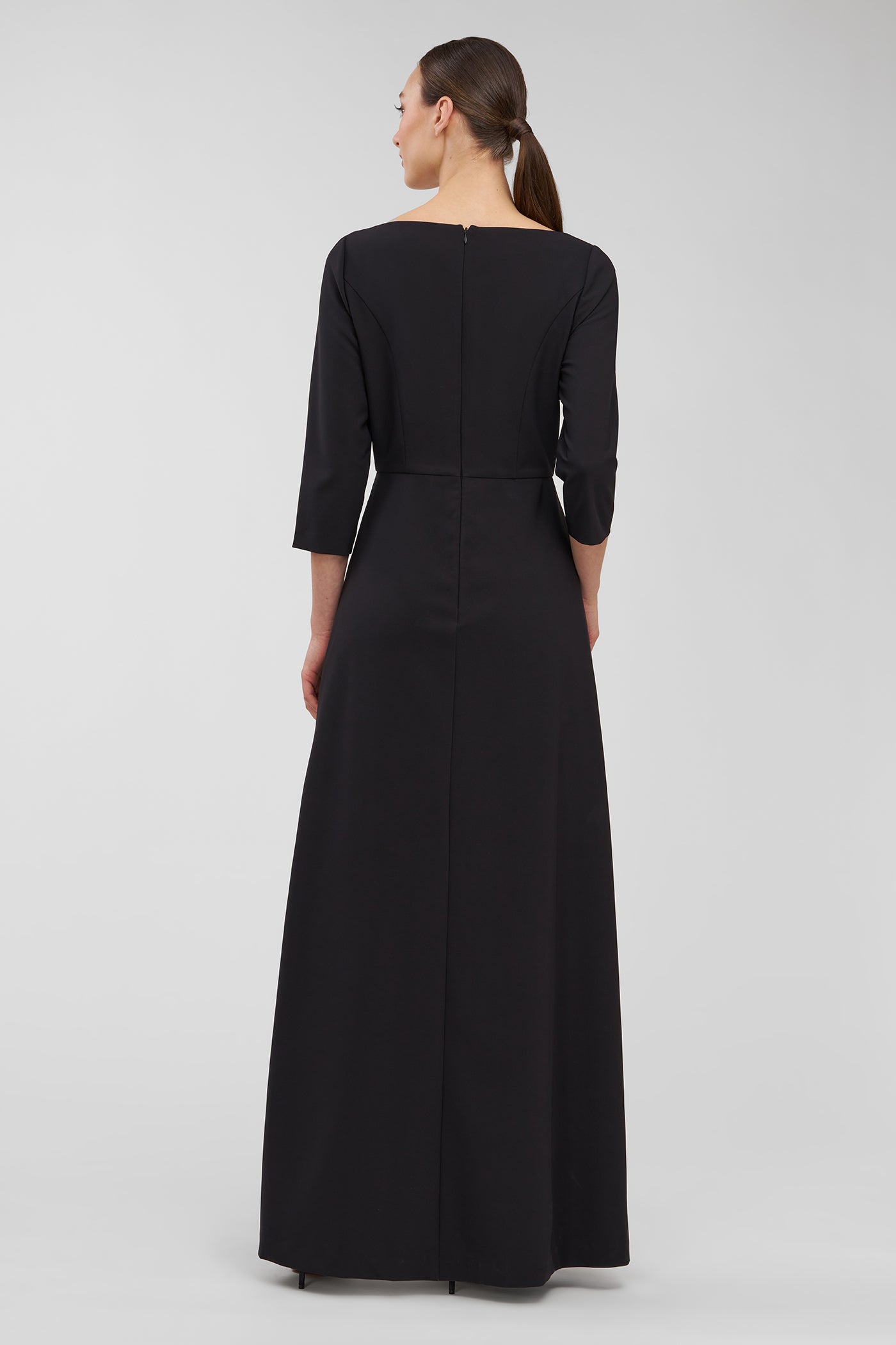 Woman wearing a black walk thru jumpsuit with long sleeves on a white background